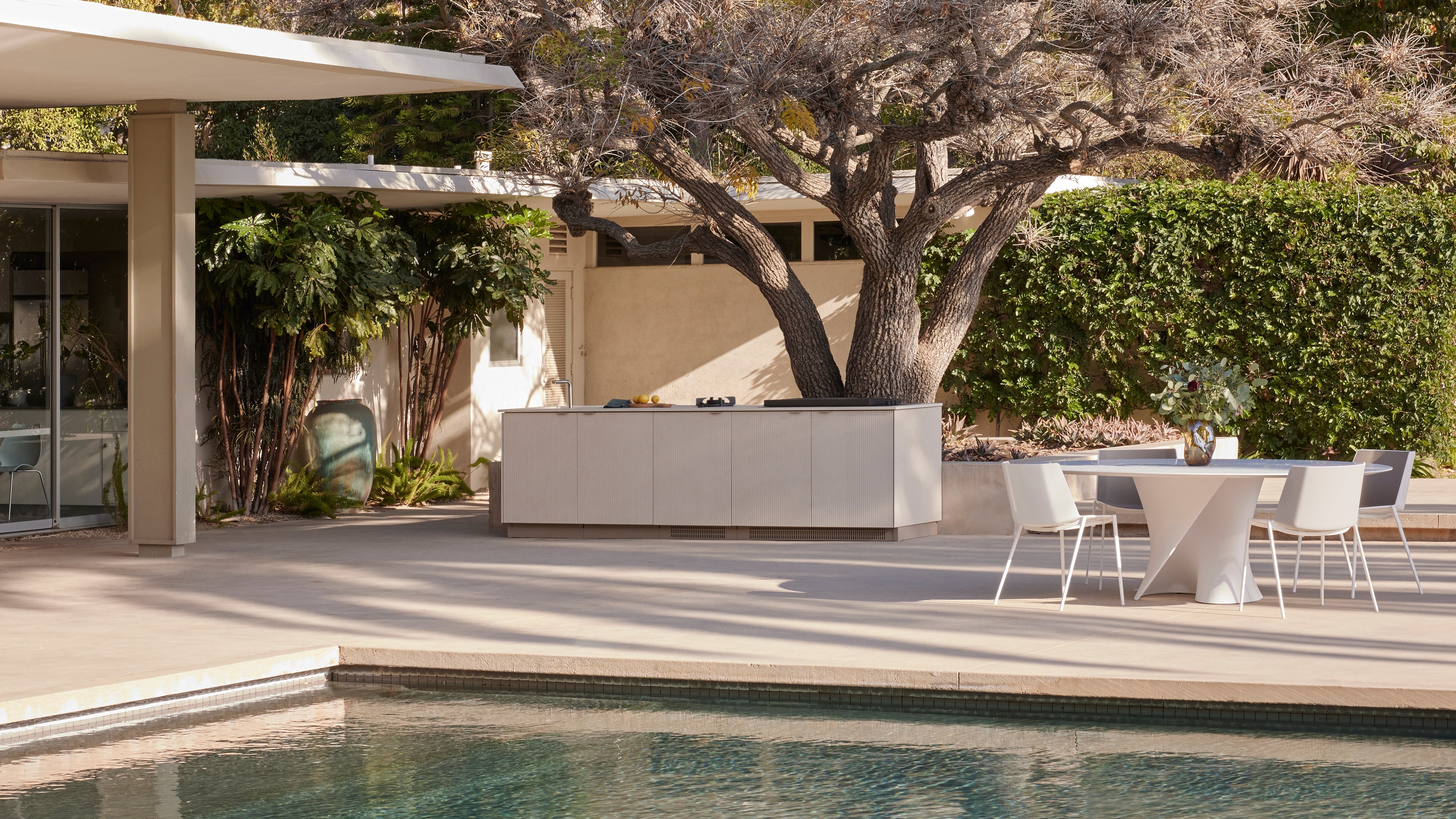 Official Urban Bonfire outdoor kitchen inspiration beside a pool and dining area